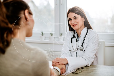 friendly female doctor holding female patient s hand for encouragement and empathy